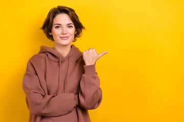 Photo of adorable promoter girl direct fingers empty space offer novelty proposition wear hood...