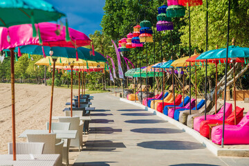 Cafe with colorful umbrellas at beach in Bali, Nusa Dua. Beach club restaurant