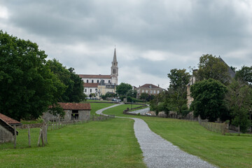 Fototapeta na wymiar Vista parcial sobre a cidade de Bidache com a Igreja de São Tiago Maior ao fundo num dia nublado em França