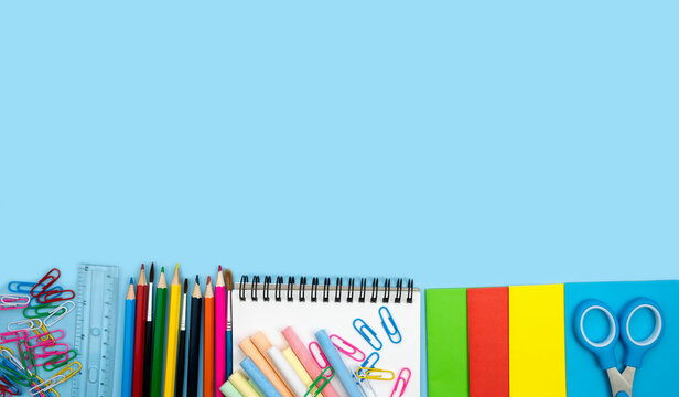 School composition with colorful school supplies on blue background. Back top school concept. Top view. Copy space.