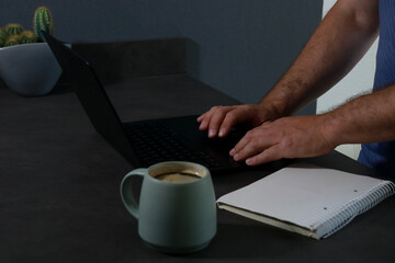 Side view of man's hands typing on laptop computer