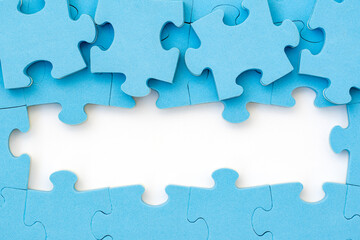 Obraz premium Four blue puzzle pieces revealing white background