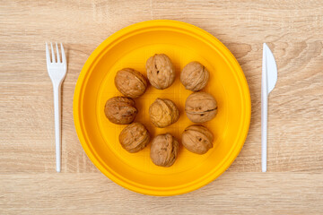 Walnuts in yellow disposable plate. Healthy food concept.