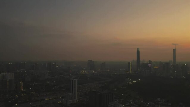  Kuala Lumpur, Malaysia June 14, 2023 Cinematic aerial view pan to right, golden sunsets in the city. 4K