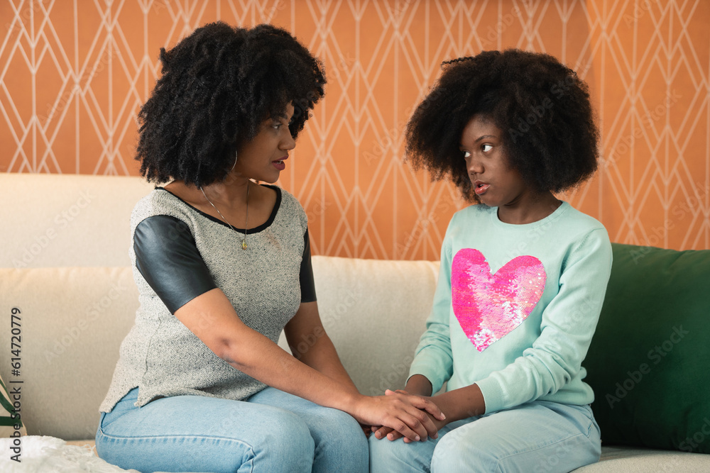 Wall mural mother comforts sad teenager on sofa in living room at home