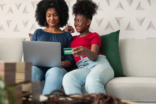 Mother And Daughter Buy Online With Credit Card In Living Room