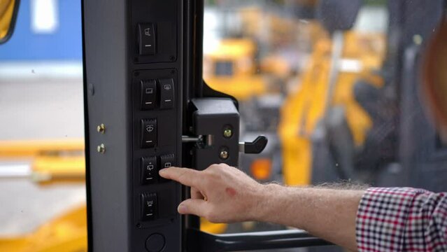 Close-up senior male hand pressing buttons in brand new agricultural harvester in slow motion. Closeup unrecognizable confident old Caucasian man choosing new vehicle sitting in tractor cabin