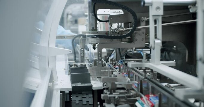 Manufacturing line at medical factory. Packaged goods at automated production line. Medical factory assembly line packing medicine machine. Production line of pharmaceutical manufacturing.