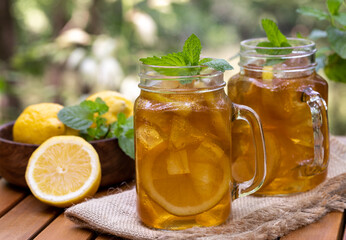 Ice tea in glass jars with lemon and mint