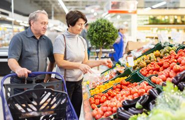 elderly husband and wife choose high-quality tomato
