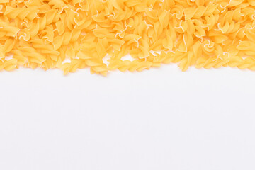 Uncooked Fusilli Pasta with Copy Space on White Background. Raw and Dry Macaroni. Fat and Unhealthy Food - Flat Lay
