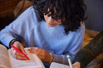 Young woman making highlights in book