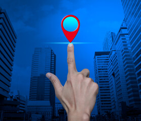 Hand pressing map pin point location button over modern city tower and skyscraper, Map pointer...