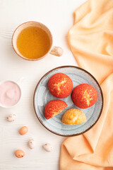 French custard dessert shu cake and cup of green tea on white wooden, top view.