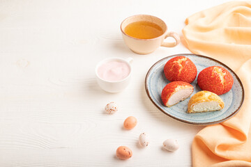French custard dessert shu cake and cup of green tea on white wooden, side view, copy space.