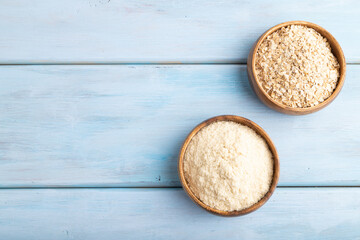 Powdered milk and oatmeal baby food mix, infant formula on blue wooden, top view, copy space
