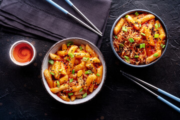 Tteokbokki or topokki and rabokki, Korean street food, spicy rice cakes, overhead flat lay shot with chopsticks and a drink