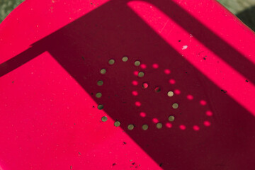 Heart engraved on an outdoor chair with a funny shadow cast by the sun, love concept