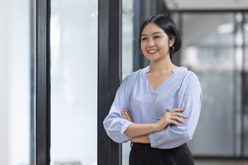 Young asian woman, professional entrepreneur standing in office clothing, smiling and looking confident, workplace office background