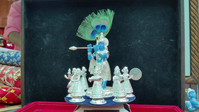 moving idol of lord krishna along with gopis, rotating round. Kanha is playing flute and making gopies dance. beautiful piece of god made of silver. captured at Nathdwara, Rajasthan. on June 03 2023