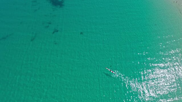 Canoe floating in ocean aerial view. Travel to tropical sea and enjoy summer