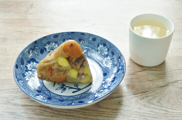 sticky rice steam with pork and salt egg of Chinese Duanwu festival on plate couple hot tea cup 