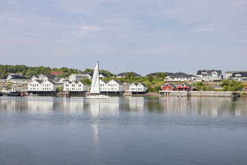 Fototapeta na wymiar Sailboat passes Brønnøysund harbour, Helgeland, Norway