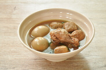 boiled egg with chicken drumstick with fried tofu in herb brown soup on bowl 