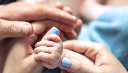 Close-up, the hands of the baby, mom and grandmother.