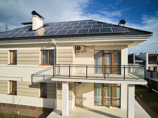 New two-storey house with photovoltaic solar panels on rooftop. Home with solar modules for generating electricity through photovoltaic effect. Power sustainable resources concept.