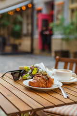 A croissant and a cup of coffee on the cafe's summer terrace