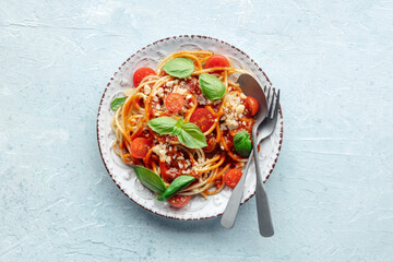 Spaghetti marinara, pasta with tomato sauce and basil, overhead flat lay shot on a slate background