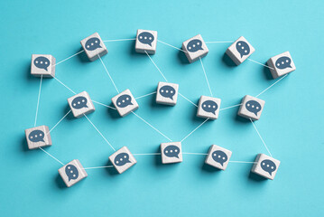 Wooden cubes with texting message chat link speech bubble each other on blue background. Online...