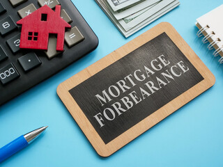 Wooden plate with inscription mortgage forbearance and model of house. - obrazy, fototapety, plakaty