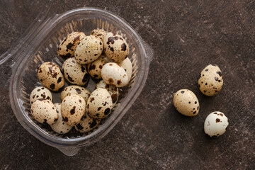 Quail eggs in a plastic packaging on a stone table. Group of quail eggs. Top view