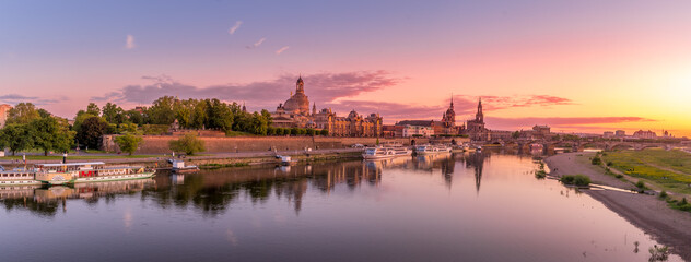 Dresden sunset view with purple, orange, red sky historic buildings in the city center reflecting...