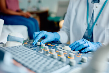 Close up of doctor using ultrasound during medical examination at clinic.