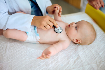 Fototapeta na wymiar Close up of pediatrician using stethoscope during baby's health checkup.