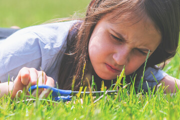 Conceptual image: Obsessive-compulsive disorder (OCD). Young beautiful girl cuts the grass with...