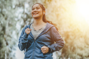 Health and lifestyle concept. Fitness, Exercising, jogging, running. Smiling Asian woman jogging at outdoor park doing morning exercise.