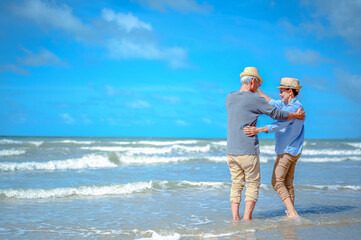 Plan life insurance of happy retirement concepts. Senior couple dancing at the beach looking the...