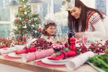 Mother and daughter setting Christmas table