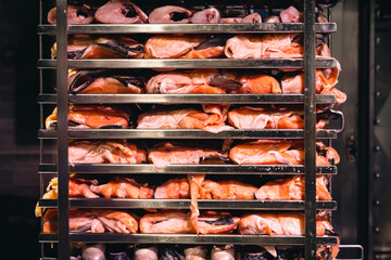 Racks of salmon smoking in a small smoker.