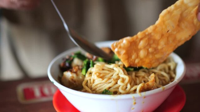 an indonesian man eat tasty asian mie ayam noodles 