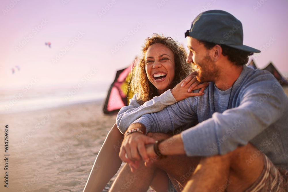 Wall mural laughing couple sitting on beach