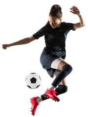Young female soccer or football player in sportwear and boots kicking ball for the goal in jump...