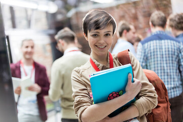 Portrait smiling female college student with backpack and laptop