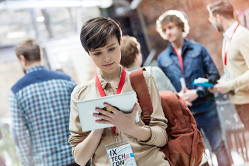 Young woman using digital tablet at technology conference