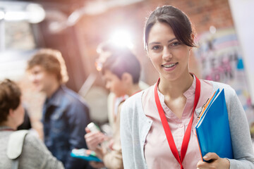 Portrait smiling woman holding folder at technology conference