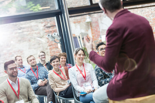 Smiling audience watching presentation at conference